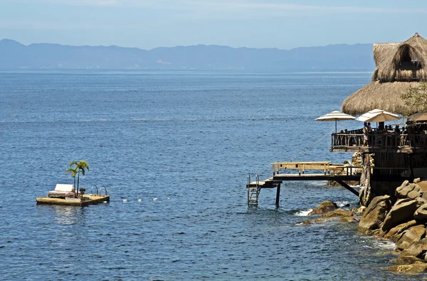 Thatched roof hut with floating deck — Stock Photo, Image