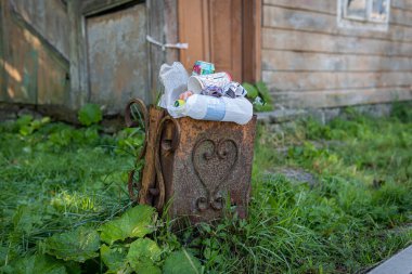 Vorohta, Ukrayna 9 Eylül 2021: Plastik şişeler ve diğer çöp, çöp ve çöplerle dolu küçük bir antika metal çöp kutusu