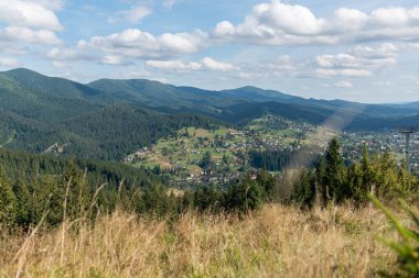 Güneşli bir yaz gününde kırsal alanda güzel bir doğa, dağlar ve orman manzarası.