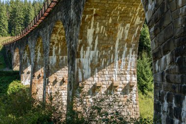 Dağlardaki büyük, eski bir su kemeri köprüsü.