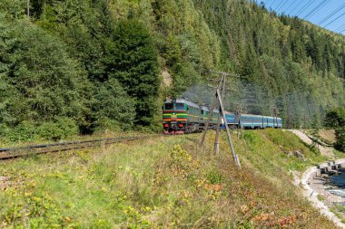 Vorokhta, Ukrayna 24 Eylül 2021: Güneşli bir günde bir tren dağlarda demiryoluna çıkıyor
