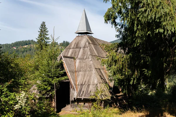 Dağlarda sıra dışı mimarisi, av kulübesi ve kulübesi olan küçük bir ev.