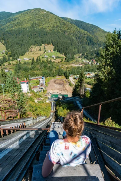 Genç bir kadın, turist, dağların ve yeşil ormanın muhteşem ve nefes kesici manzarasını seyrediyor.