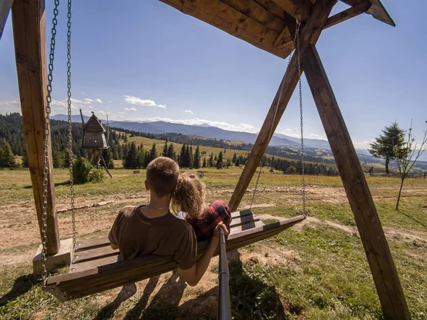 Güneşli bir günde, dağlarda birlikte eğlenen sevimli bir çift.