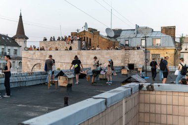 Kyiv (Kiev), Ukrayna - 17 Temmuz 2021: Sıcak ve güneşli bir günde çatıda dinlenen ve eğlenen pek çok genç, tarihi bina Kvity Ukrayiny 'nin yıkımına karşı gösteri yapıyor (Ukrayna Çiçekleri))