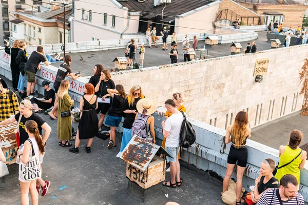 Kyiv (Kiev), Ukrayna - 17 Temmuz 2021: Sıcak ve güneşli bir günde çatıda dinlenen ve eğlenen pek çok genç, tarihi bina Kvity Ukrayiny 'nin yıkımına karşı gösteri yapıyor (Ukrayna Çiçekleri))