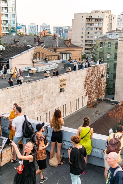 Kyiv (Kiev), Ukrayna - 17 Temmuz 2021: Sıcak ve güneşli bir günde çatıda dinlenen ve eğlenen pek çok genç, tarihi bina Kvity Ukrayiny 'nin yıkımına karşı gösteri yapıyor (Ukrayna Çiçekleri))