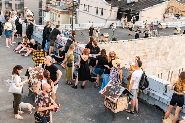Kyiv (Kiev), Ukrayna - 17 Temmuz 2021: Sıcak ve güneşli bir günde çatıda dinlenen ve eğlenen pek çok genç, tarihi bina Kvity Ukrayiny 'nin yıkımına karşı gösteri yapıyor (Ukrayna Çiçekleri))