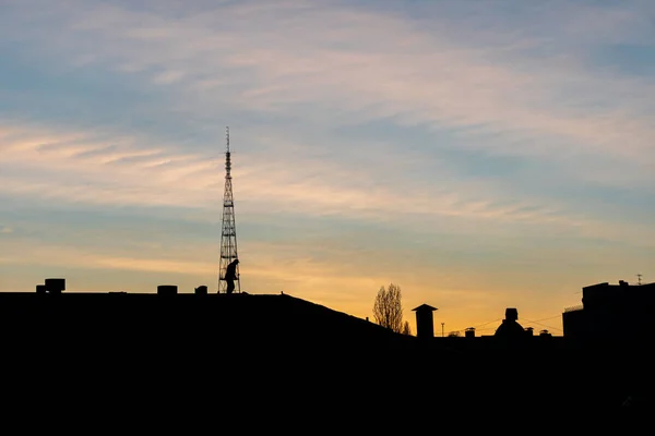 日落时分 两个人在一座城市建筑的屋顶上工作的轮廓 黄金时间 大塔和住宅楼 — 图库照片