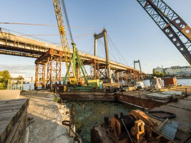 Kyiv, Ukrayna Temmuz 04, 2017: Büyük, eski ve paslı bir deniz vinci. Bina, bir köprünün yeniden inşası. Nehir kenarındaki sanayi bölgesi. 