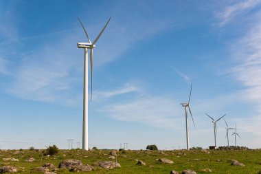 İsveç, Kristianstad 17 Mayıs 2022: Büyük rüzgar türbinleri, açık havada elektrik jeneratörleri, mavi gökyüzü. 