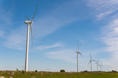 İsveç, Kristianstad 17 Mayıs 2022: Büyük rüzgar türbinleri, açık havada elektrik jeneratörleri, mavi gökyüzü. 