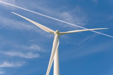 İsveç, Kristianstad 17 Mayıs 2022: Büyük rüzgar türbinleri, açık havada elektrik jeneratörleri, mavi gökyüzü. 