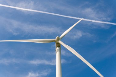 İsveç, Kristianstad 17 Mayıs 2022: Büyük rüzgar türbinleri, açık havada elektrik jeneratörleri, mavi gökyüzü. 