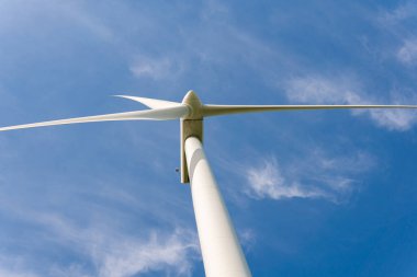 İsveç, Kristianstad 17 Mayıs 2022: Büyük rüzgar türbinleri, açık havada elektrik jeneratörleri, mavi gökyüzü. 