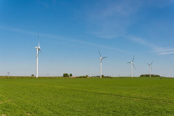 İsveç, Kristianstad 17 Mayıs 2022: Büyük rüzgar türbinleri, açık havada elektrik jeneratörleri, mavi gökyüzü. 