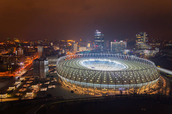 Ukraine, Kyiv  November 18, 2014: Aerial panoramic view on National Sports Complex Olympiyskiy, big round stadium. Central part of city, residential area in the evening. Night life.
