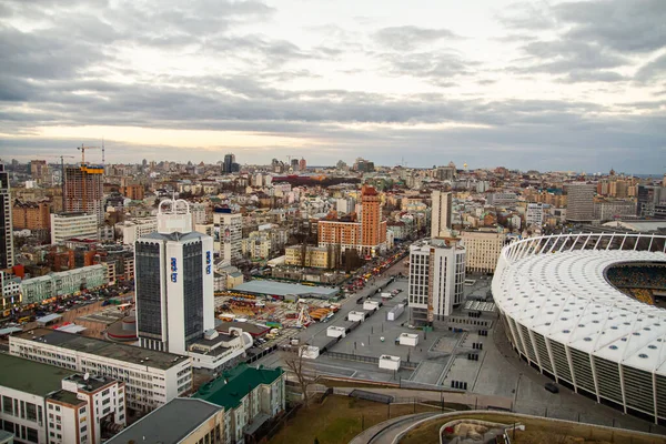 Ukrayna, Kyiv 25 Aralık 2014: Ulusal Spor Kompleksi Olympiyskiy 'de havadan panoramik manzara, büyük yuvarlak stadyum. Şehrin merkezi, akşamları yerleşim bölgesi. Gece hayatı.