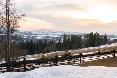 Ormanlı, kayalı, devasa karlı dağlar. Panorama en üstte, hava manzaralı. Dağlarda ıssız bir ev..
