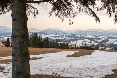 Ormanlı, kayalı, devasa karlı dağlar. Panorama en üstte, hava manzaralı. Dağlarda ıssız bir ev..