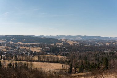 İlkbaharda karlı dağların ve tepelerin nefes kesici manzarası, orman ve köy, panoramik manzara 
