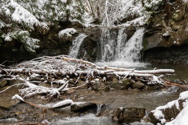 Kışın güzel, küçük şelaleler ormanda, karlı tepelerde, açık havada.