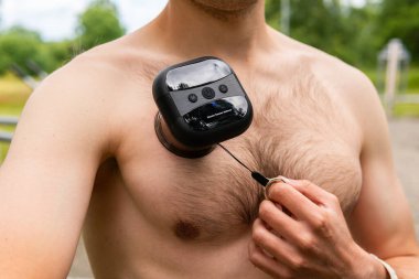 Intelligent, smart muscle tension reliever gadget, air cup cupping massager on a naked muscled male body