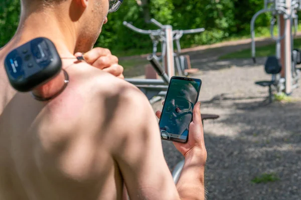 Intelligent, smart muscle tension reliever gadget, air cup cupping massager on a naked muscled male body