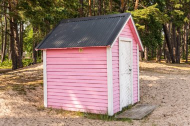 Little cozy pink wooden house on a beach