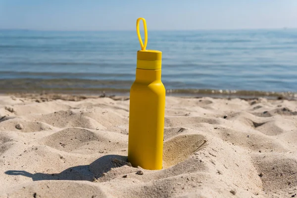 Una Botella Amarilla Termos Pie Arena Una Playa Océano Soleado — Foto de Stock