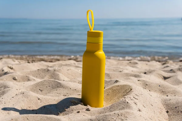 Una Botella Amarilla Termos Pie Arena Una Playa Océano Soleado — Foto de Stock