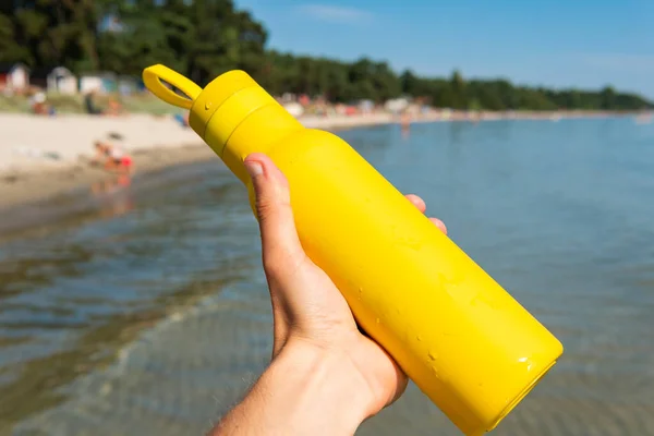 Mantener Una Botella Amarilla Las Manos Termo Una Playa Océano — Foto de Stock