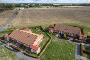 Bir tarlaya yakın özel evlerin hava görüntüsü. İnsanlar ve doğa. Küçük bir Avrupa köyü. Modern köy ve büyük bir tarla. Karşıtlıklar. 