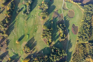Büyük bir golf sahasının havadan görünüşü, güzel yeşil çimenler, sonbaharda tarlalar ve ağaçlar.