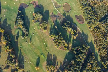 Büyük bir golf sahasının havadan görünüşü, güzel yeşil çimenler, sonbaharda tarlalar ve ağaçlar.