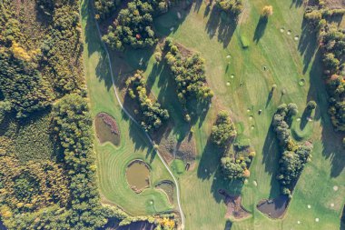 Büyük bir golf sahasının havadan görünüşü, güzel yeşil çimenler, sonbaharda tarlalar ve ağaçlar.