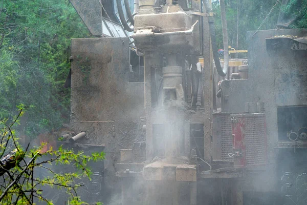 Crawler drilling rig drills a well, a lot of dust when drilling a borehole.