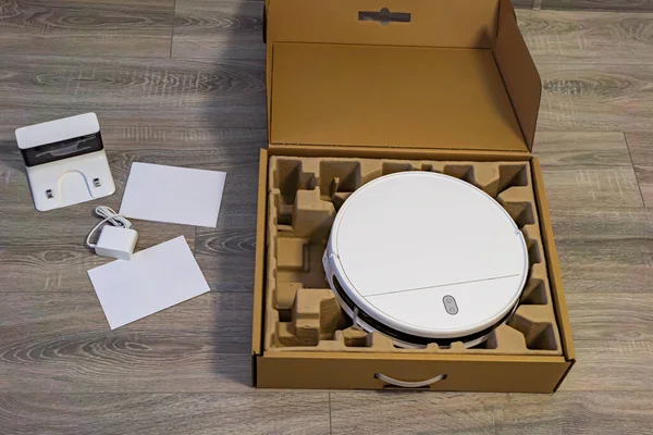 Satın alındıktan sonra robot elektrik süpürgesinin ilk açılması. Robot süpürgesi açık bir karton kutuda.