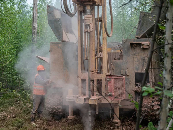 Crawler drilling rig drills well, lot of dust when drilling borehole