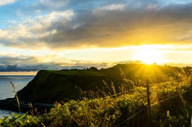 Okyanusun üzerindeki yeşil uçurumun üzerinde şafak. Camino de Santiago