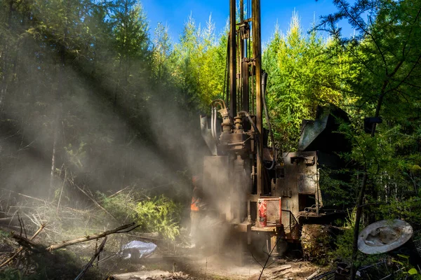 Working process of drilling a geological well. Dust when drilling borehole. drilling rig in the forest is drilling well