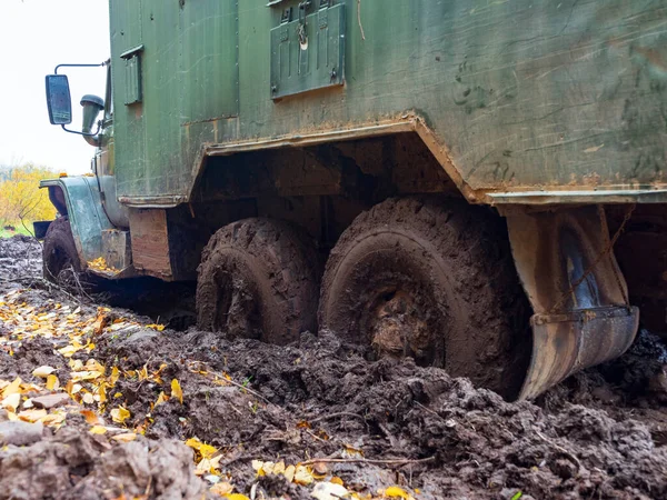 lorry truck got stuck on a dirty, broken forest off-road.