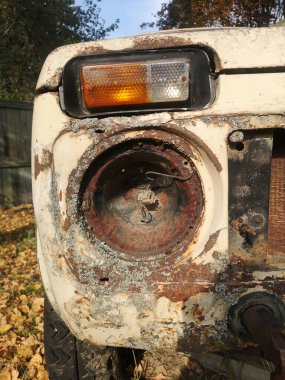 Dışarıda terk edilmiş eski bir arabanın ön farının ayrıntıları.