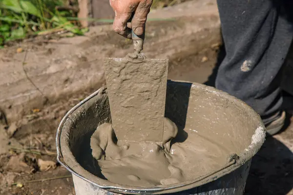Bahçe yolunu doldurmak için çimento karıştırmak, bahçe inşaatı.