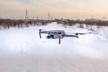 Kışın karlı bir arazide uçan kuadkopter dronu..