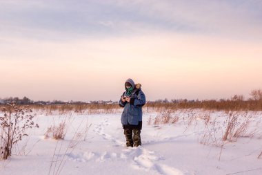 Mavi ceketli beyaz adam uzaktan kumandayla uçan bir dron fırlatıyor.