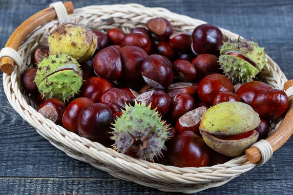 Kastanien in einem Korb auf einem hölzernen Hintergrund — Stockfoto