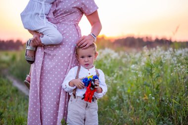Neşeli çocuk sahada bir robotla oynuyor ve ailesi yanında.