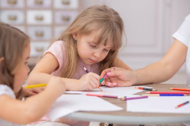 Anne ve kızları oturma odasında yerde otururken birlikte çekiliyorlar. Mutlu aile kavramı.