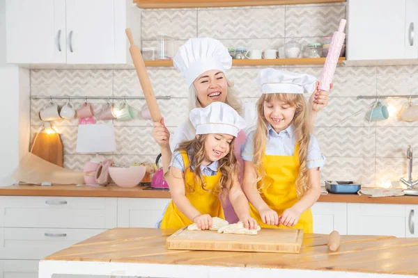 快乐的高加索母亲帮助她的学龄前女儿为自制烘焙面团 两代女性家庭在厨房一起做饭 — 图库照片